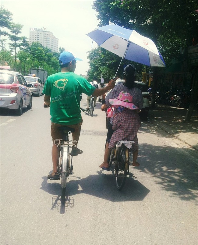 hinh-anh-de-thuong-ngay-ha-noi-nong-dinh-diem-nguoi-dan-ong-chay-xe-dap-che-o-cho-hai-me-con-t...jpg